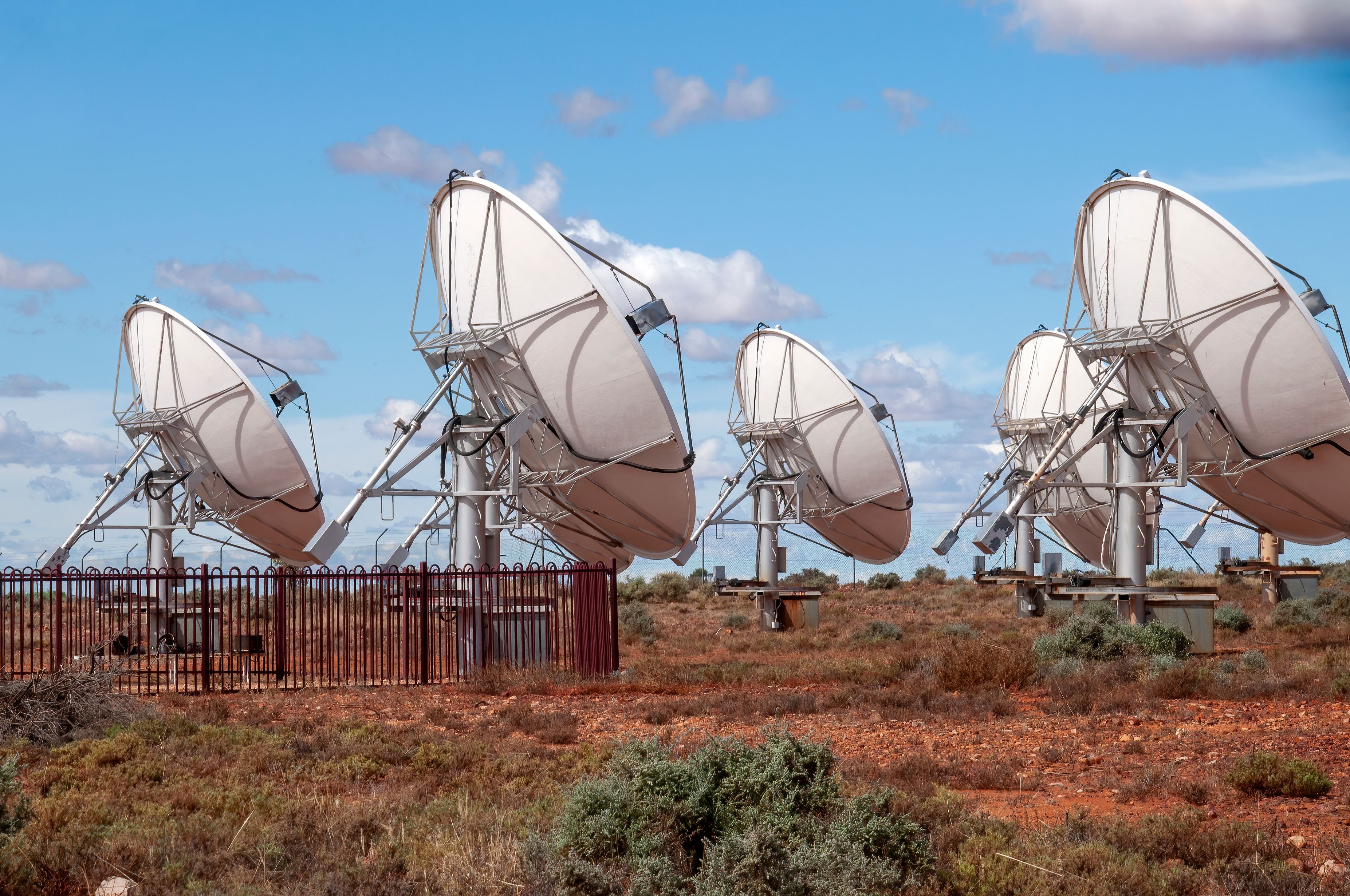 Paisaje desértico con múltiples antenas satelitales grandes.