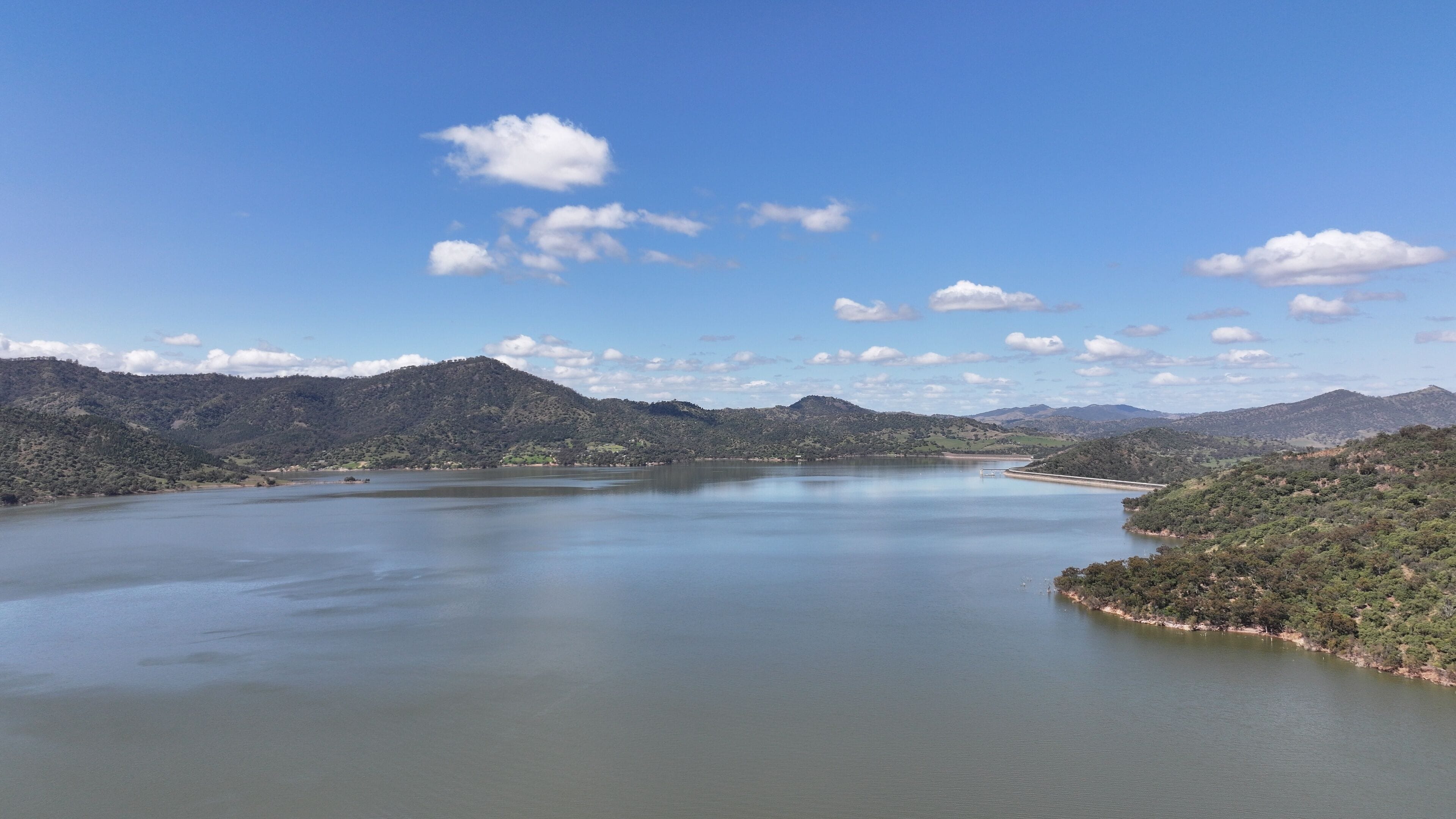 A large lake surrounded by mountains and a clear sky.