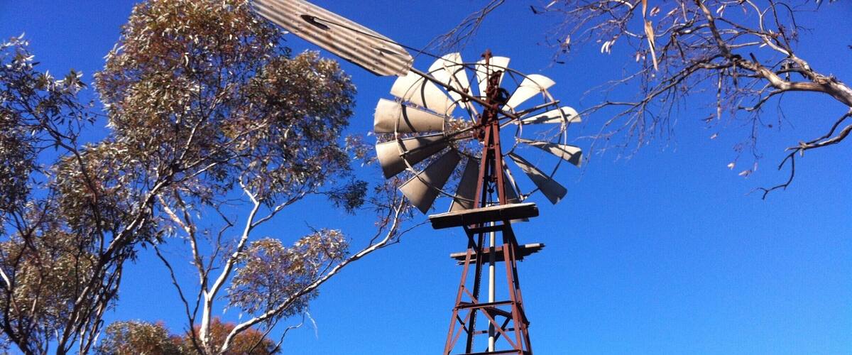 A windmill with a metal tower and a roof.