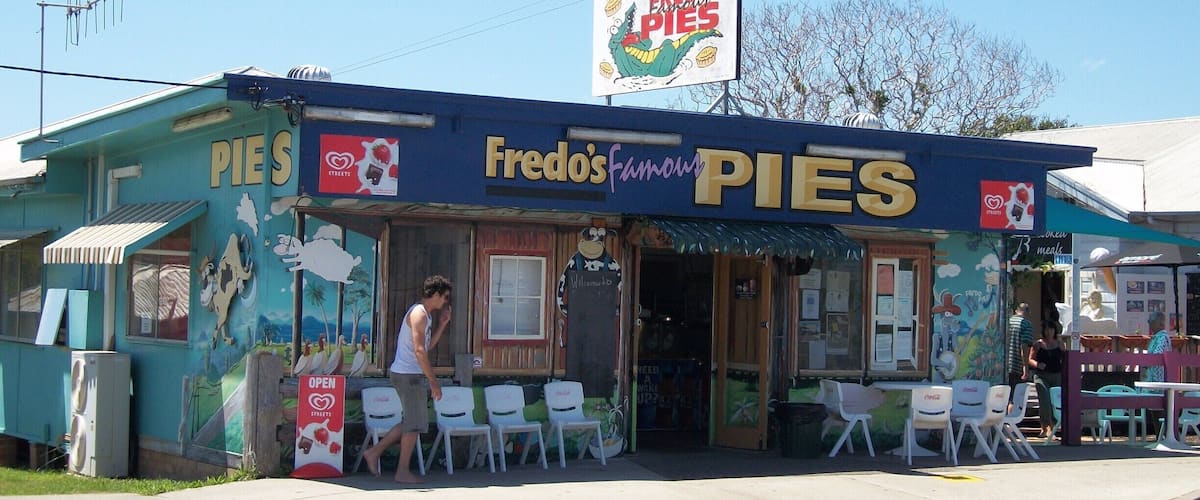 A small, colorful pie shop named Fredo's Famous Pies with outdoor seating.