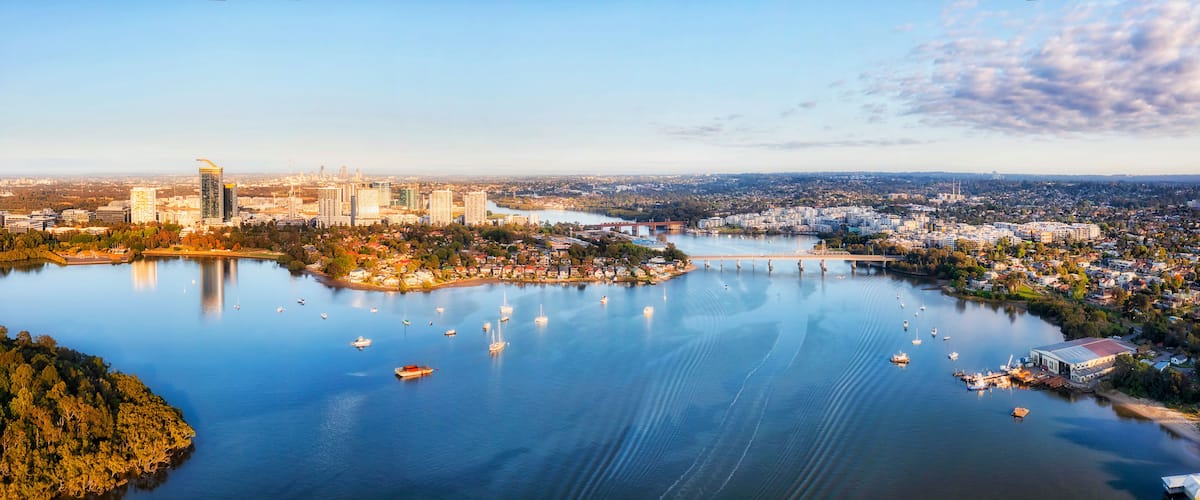 A cityscape with a river, boats, and a bridge.