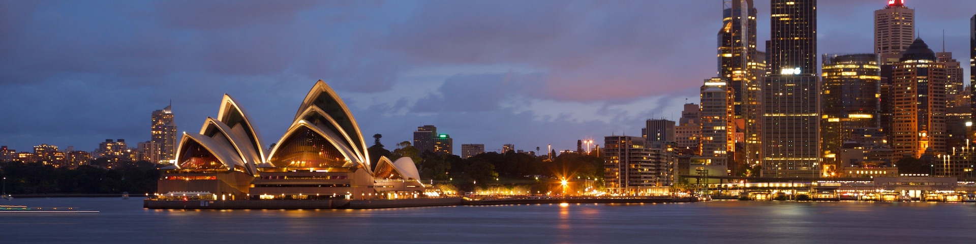 The Sydney Opera House and Sydney skyline at dusk.