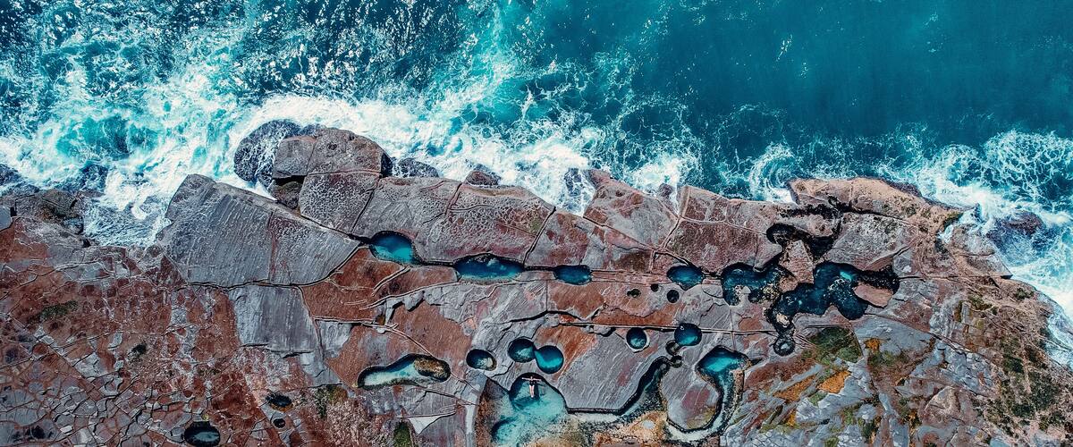 A coastal landscape with rocky terrain and turquoise pools.