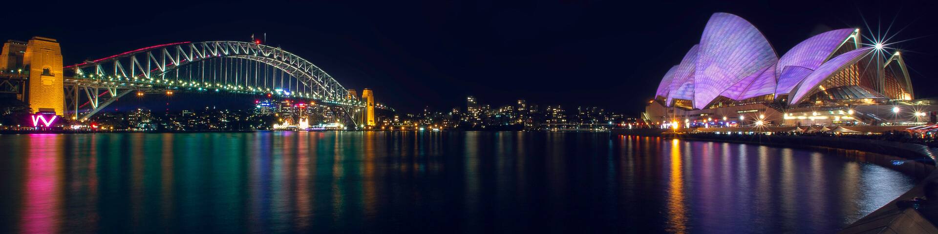 The Sydney Opera House and the Sydney Harbour Bridge at night.