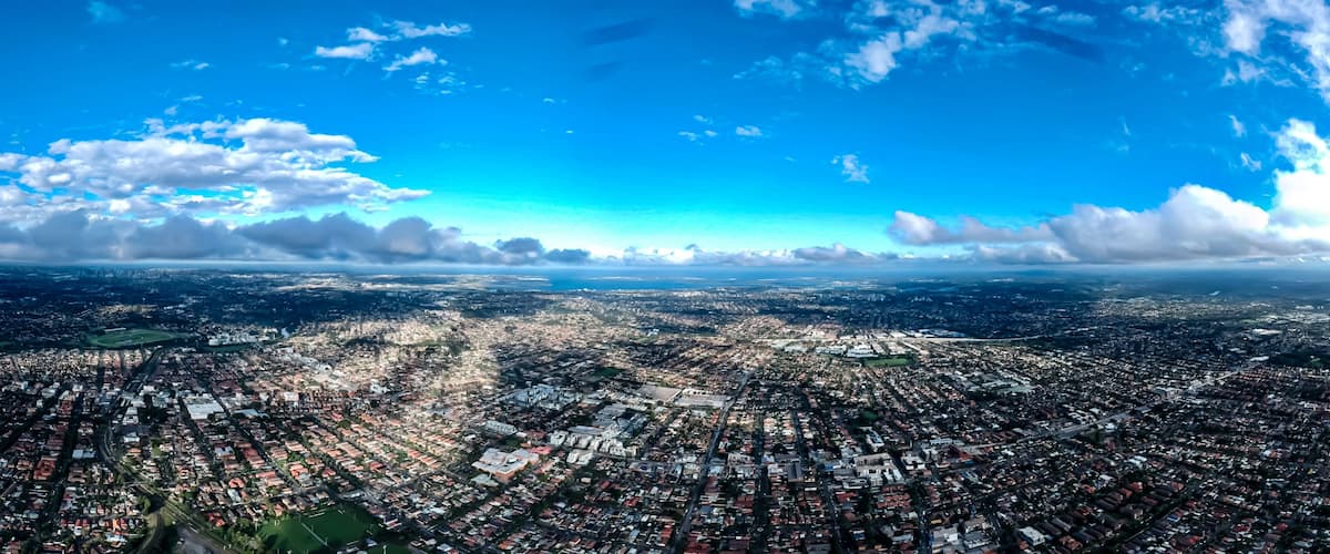 Vista panorámica de una ciudad densamente poblada con cielo despejado y algunas nubes.