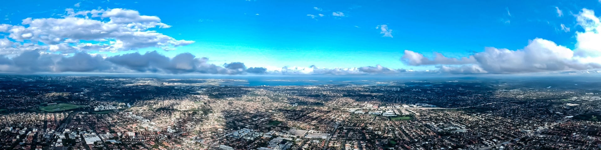 Vista panorâmica de uma cidade densamente povoada, com céu claro e algumas nuvens.