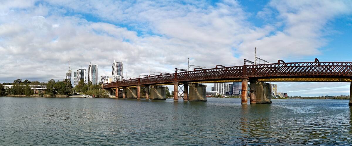 Un puente sobre un cuerpo de agua, con el horizonte de una ciudad al fondo.