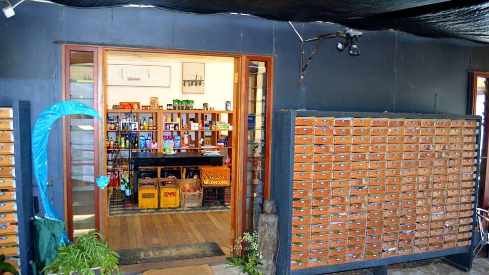 A store with wooden shelves and a blue umbrella outside.