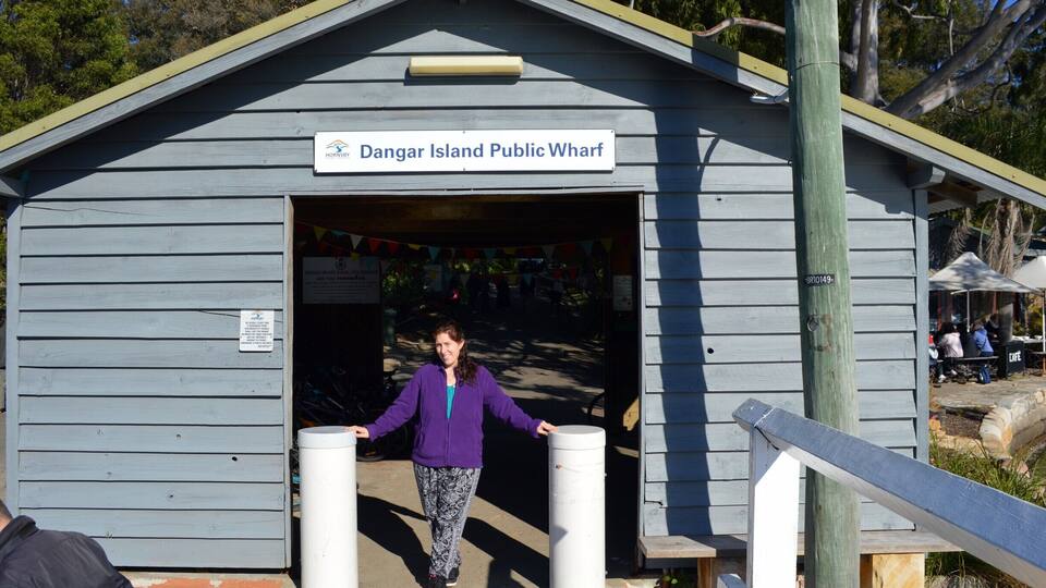 A wooden building labeled 'Dangar Island Public Wharf' with a person standing at the entrance.