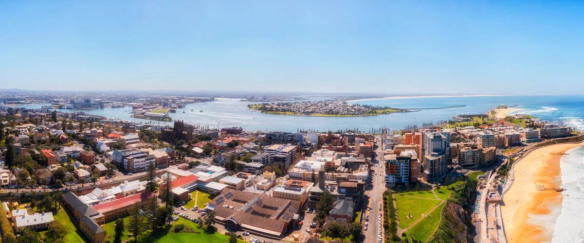 Una ciudad costera con un río, una playa y una mezcla de edificios residenciales y comerciales.