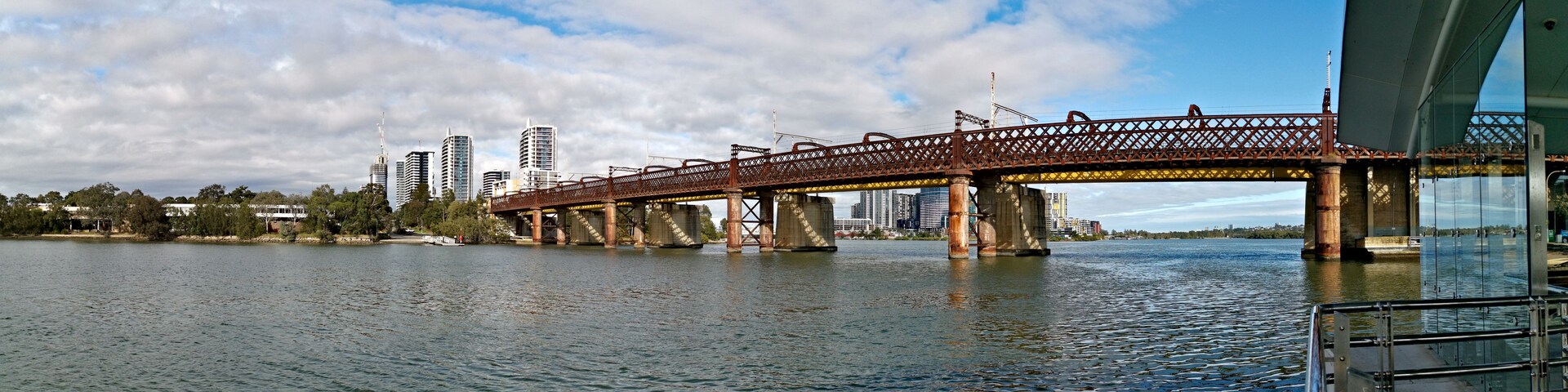 A bridge over water with a city skyline in the background.
