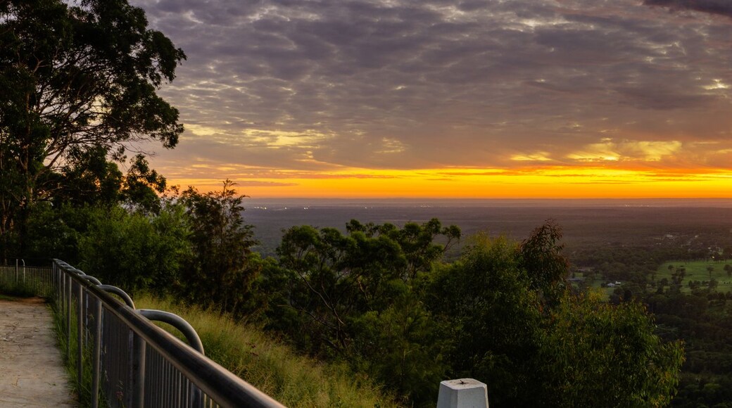 A panoramic landscape with a sunset, a river, and a forested area.