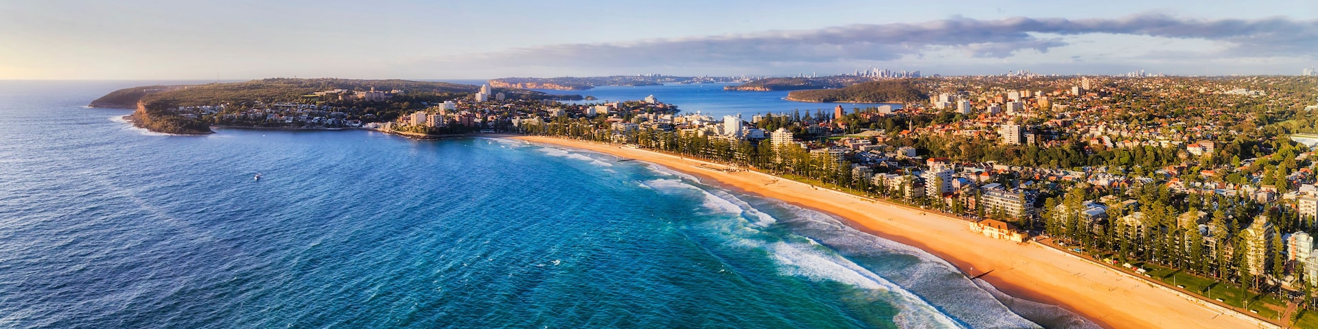 Eine Küstenstadt mit Strand, Meer und weiter Skyline.