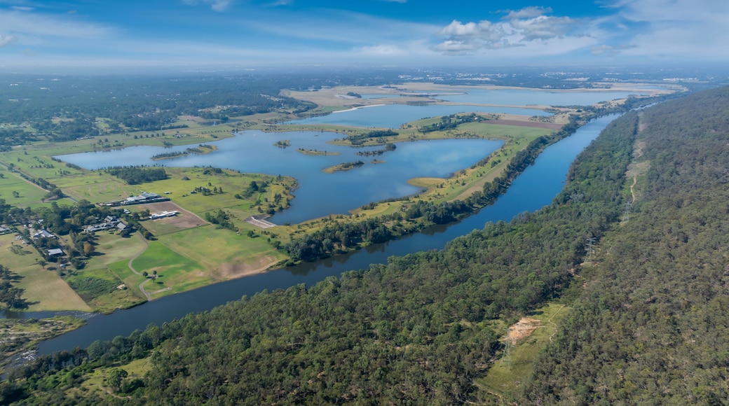 A river winding through a forested landscape with several ponds and a small settlement.