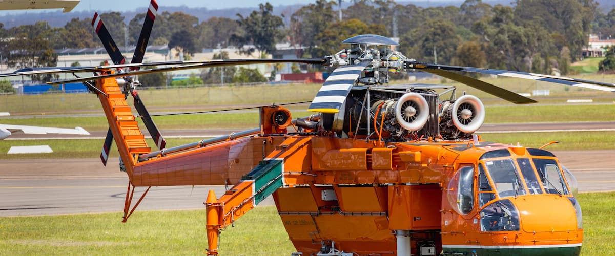 Un helicóptero naranja grande con un rotor sobre un campo de césped.
