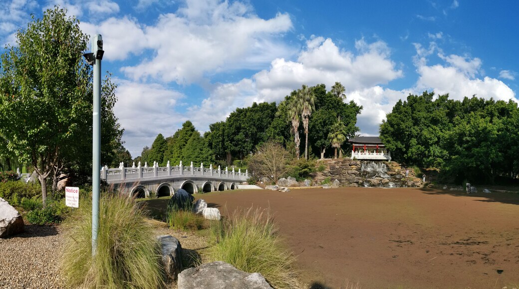 Un puente de piedra, un estanque y un pabellón tradicional.