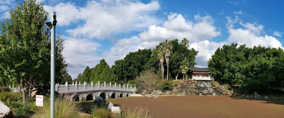 A stone bridge, a pond, and a traditional pavilion.