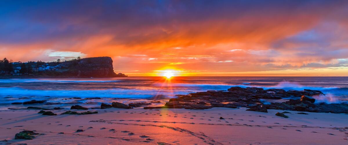 Winter sunrise by the sea shore with rain clouds