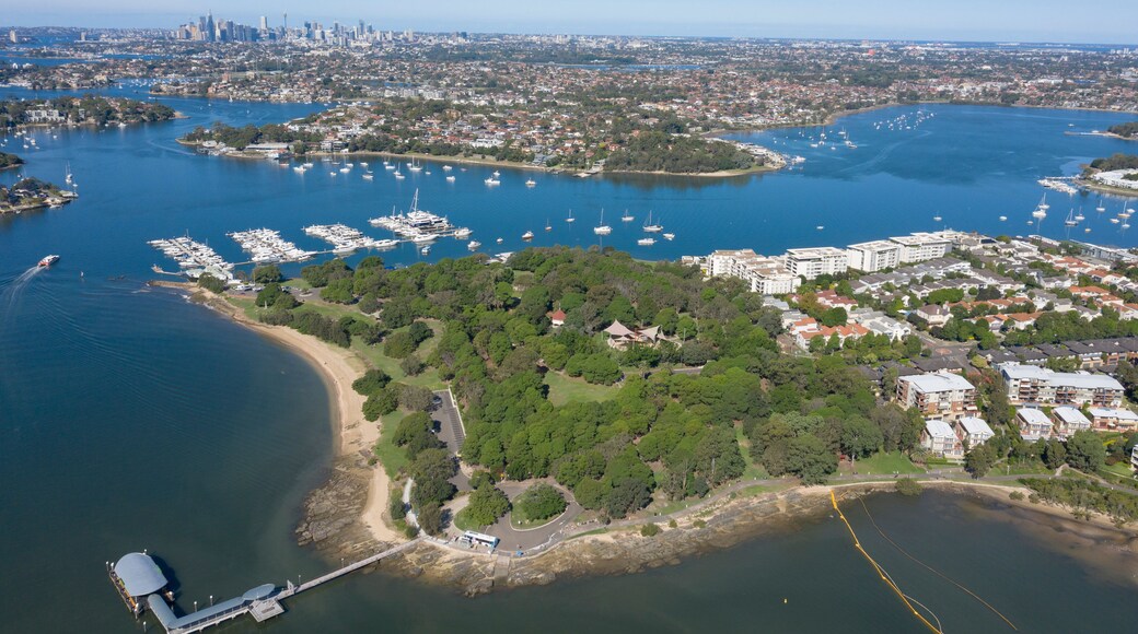 A coastal cityscape with a marina, residential areas, and a distant city skyline.