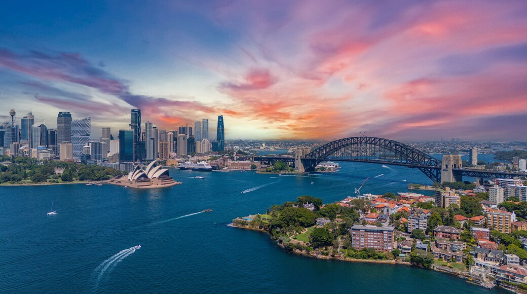 A cityscape with a prominent bridge, a waterfront, and the Sydney Opera House.