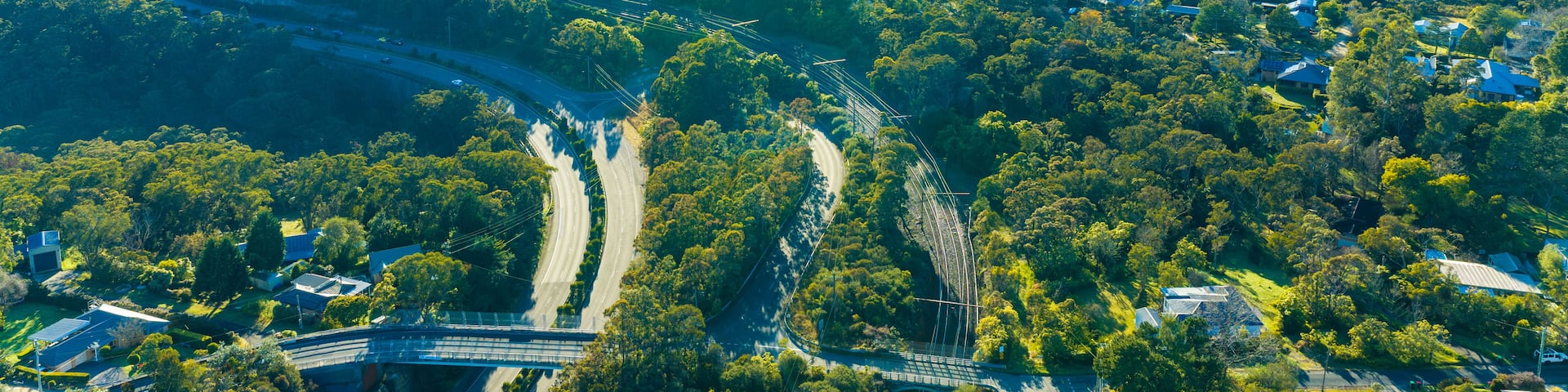 A river winding through a valley with scattered houses and a bridge.