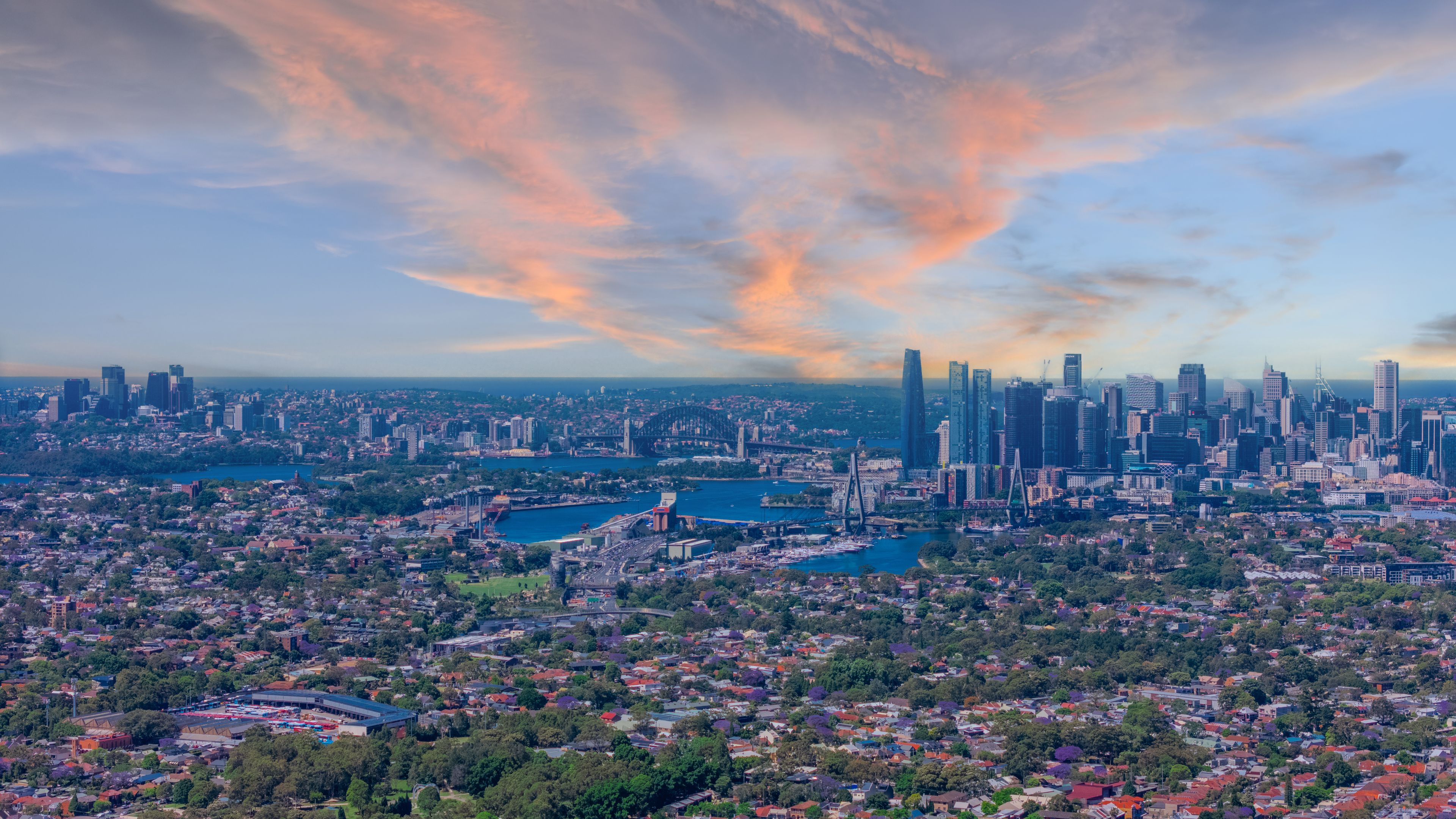 A cityscape with a prominent skyline, a large body of water, and surrounding greenery.