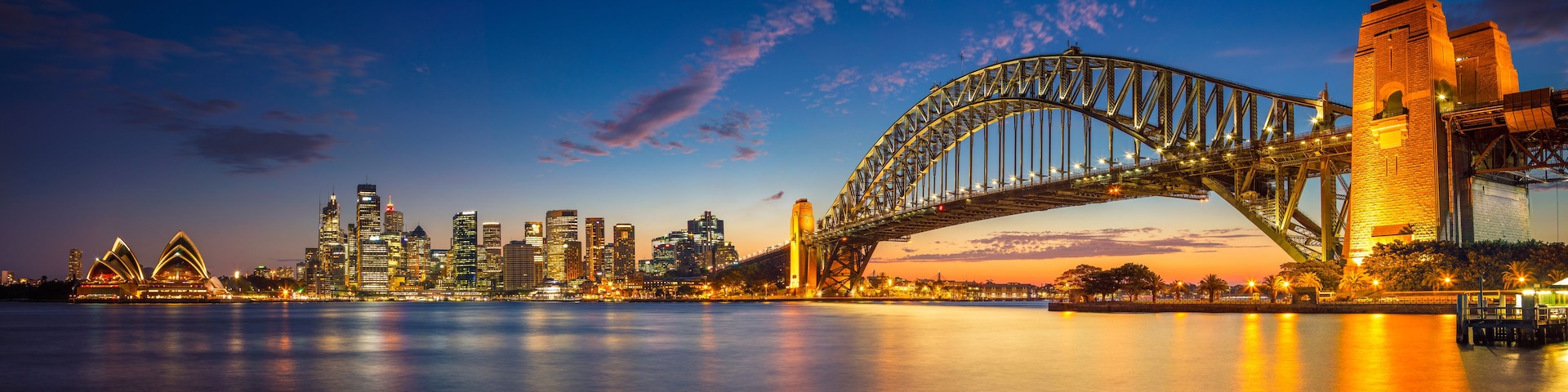 The Sydney Opera House and Sydney Harbour Bridge at dusk.