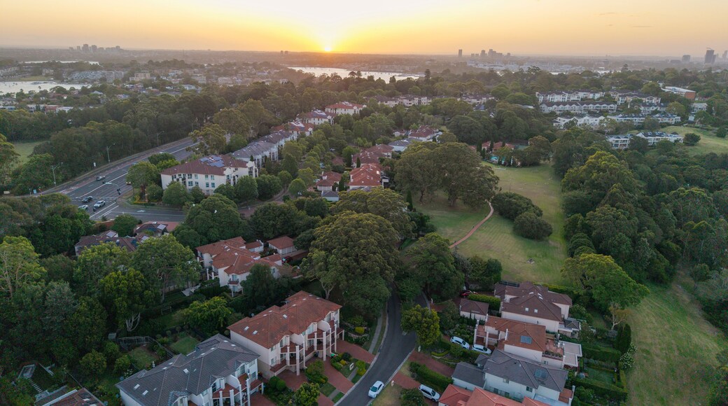 A residential area with houses, trees, and a river.