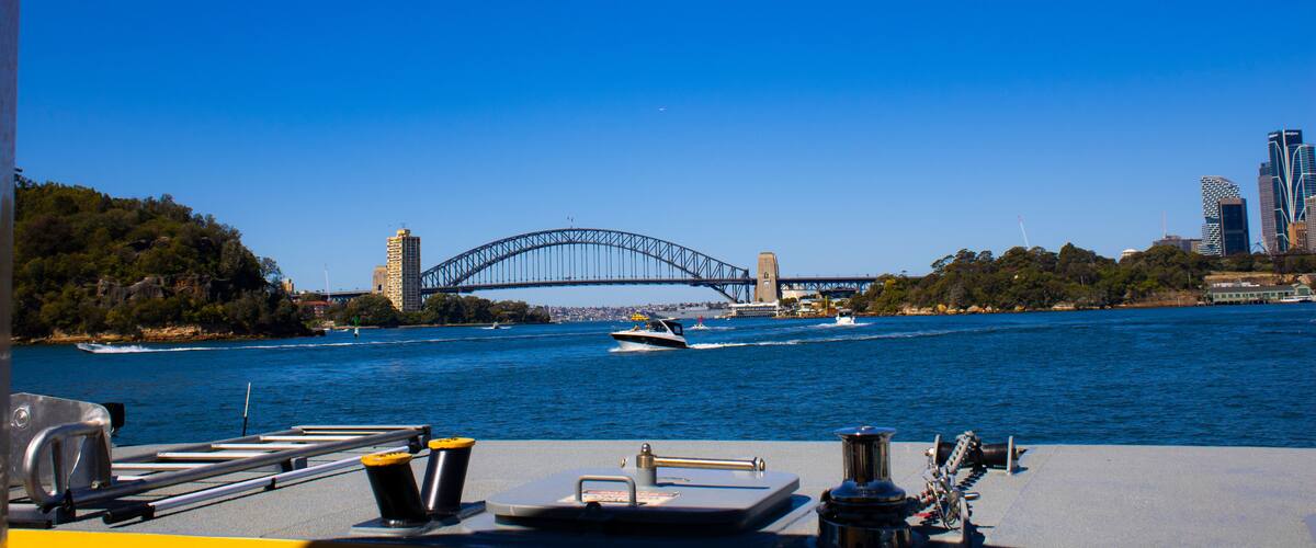 A boat on a river with a bridge in the background.