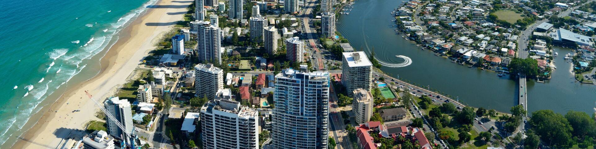 A coastal city with a beach, high-rise buildings, and a river.