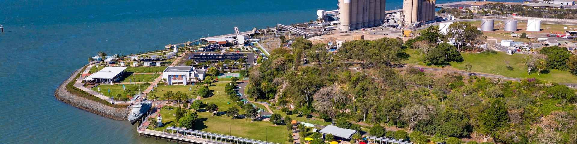 An industrial area with large storage tanks, a bridge, and a waterfront.