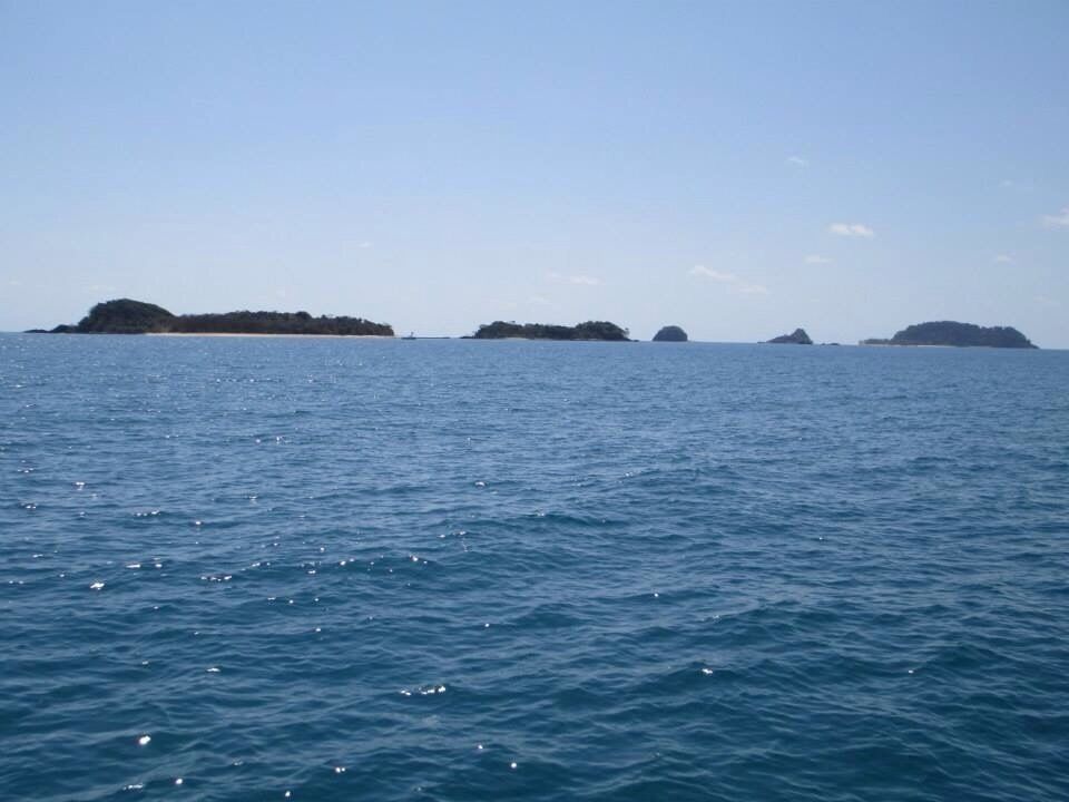 Calm ocean waters with several small islands in the distance.
