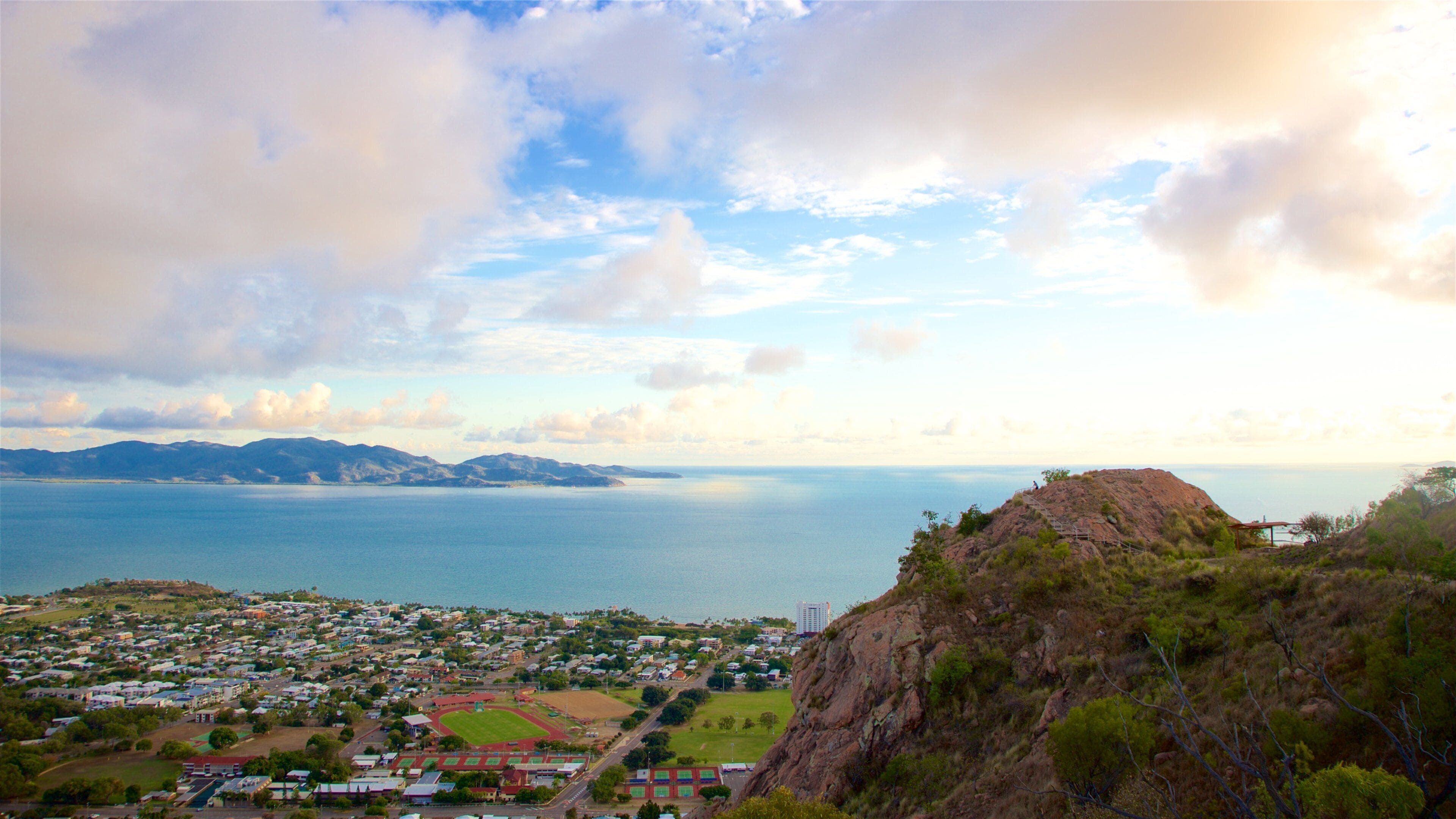 A coastal town with a view of the sea and mountains in the distance.