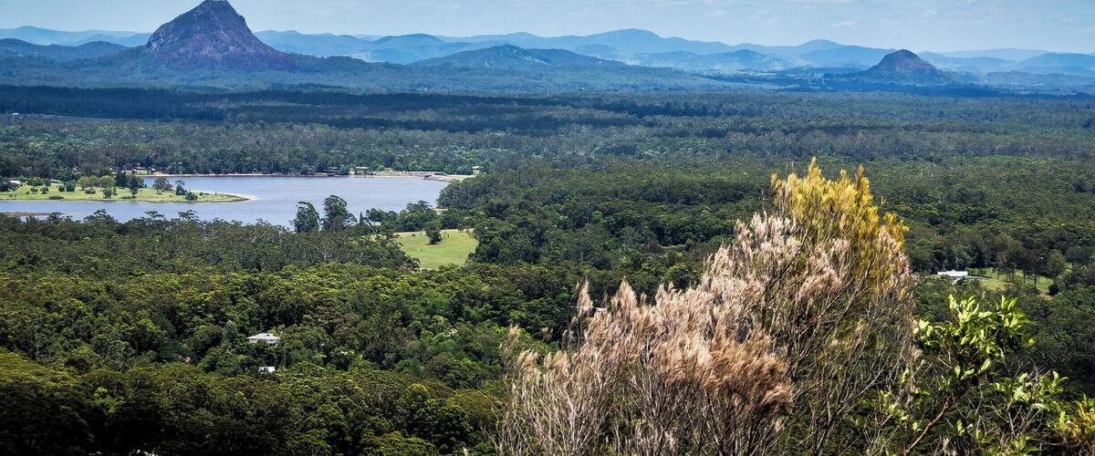 A mountainous landscape with a lake and dense forest.