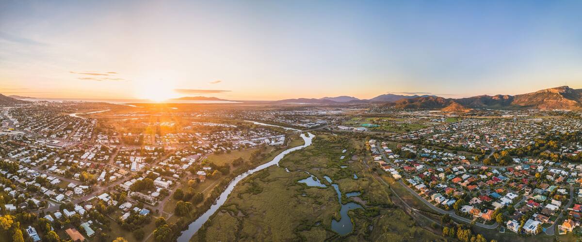 A panoramic view of a city at sunset with a river running through it.