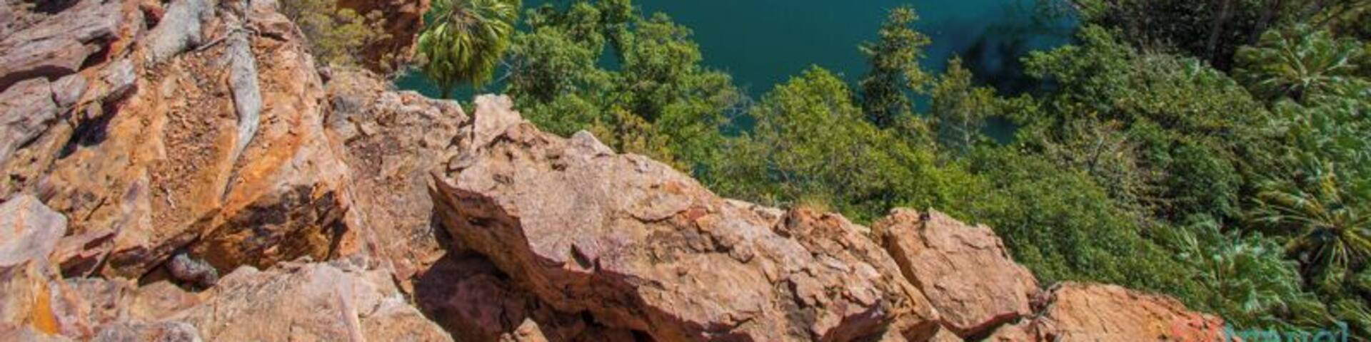 A river surrounded by rocky cliffs and dense greenery.