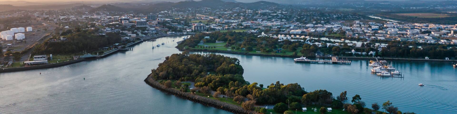 A river meandering through a city with a park and marina.