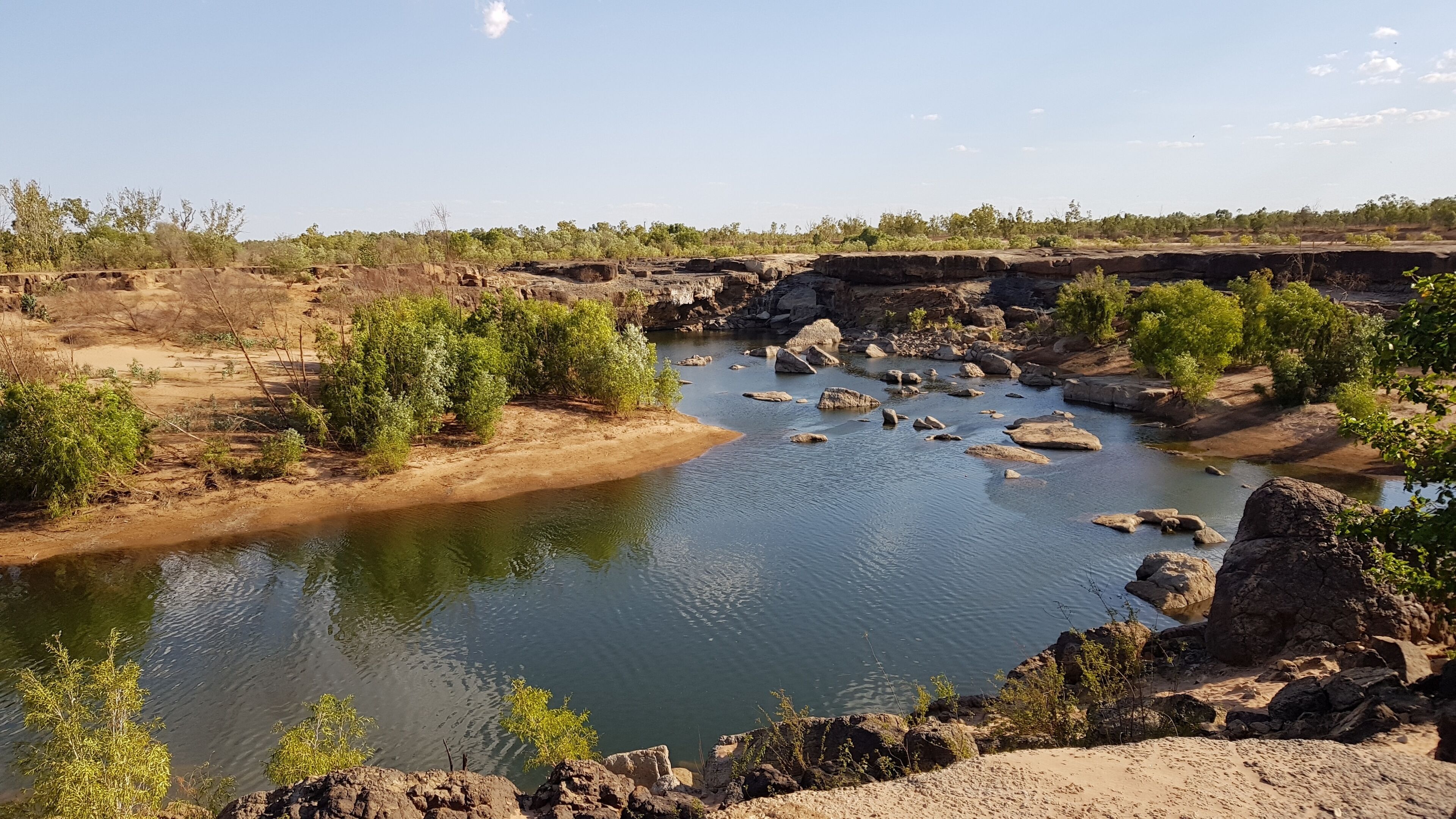 A river with rocky banks and sparse vegetation.