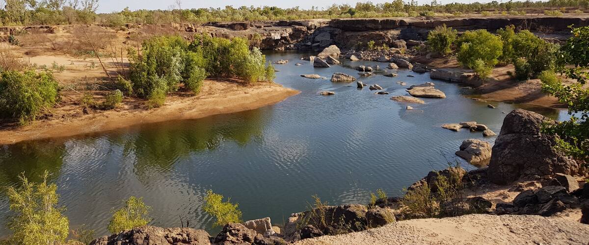 A river with rocky banks and sparse vegetation.