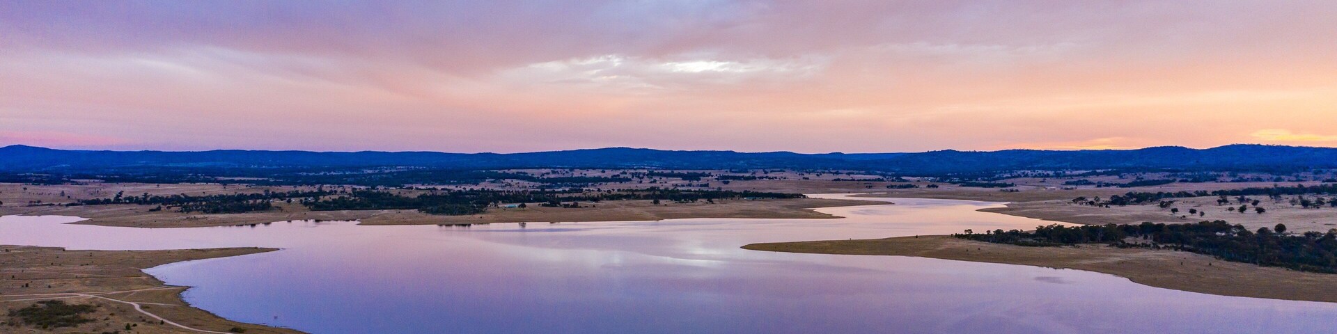 Leslie Dam showing a sunset, landscape views and a river or creek