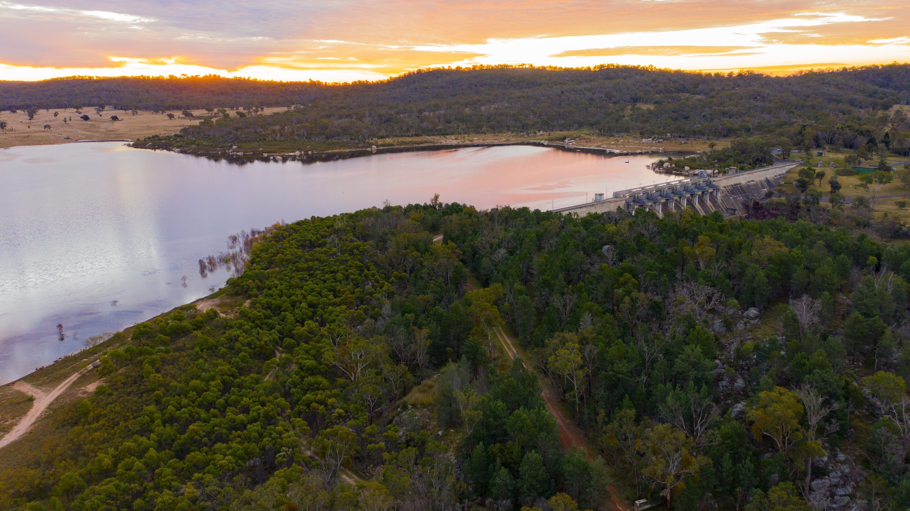 A lake surrounded by dense forest and hills.