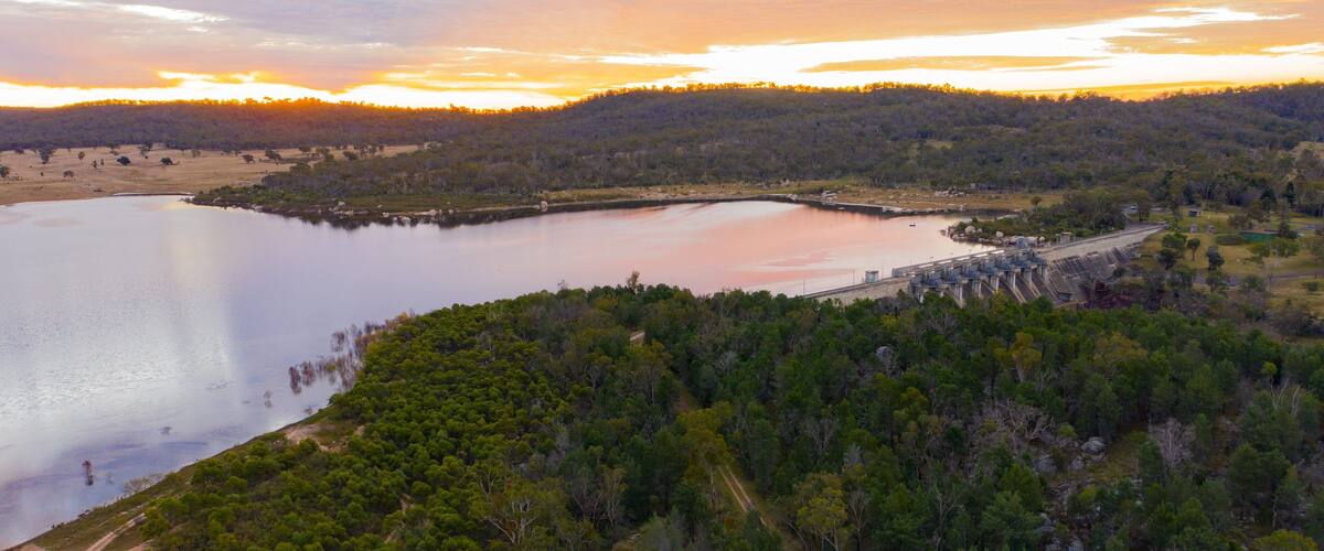 A lake surrounded by dense forest and hills.