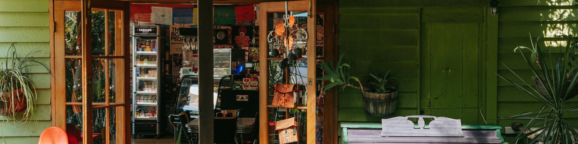Una tienda rústica con estantes de madera, un piano y diversas plantas.