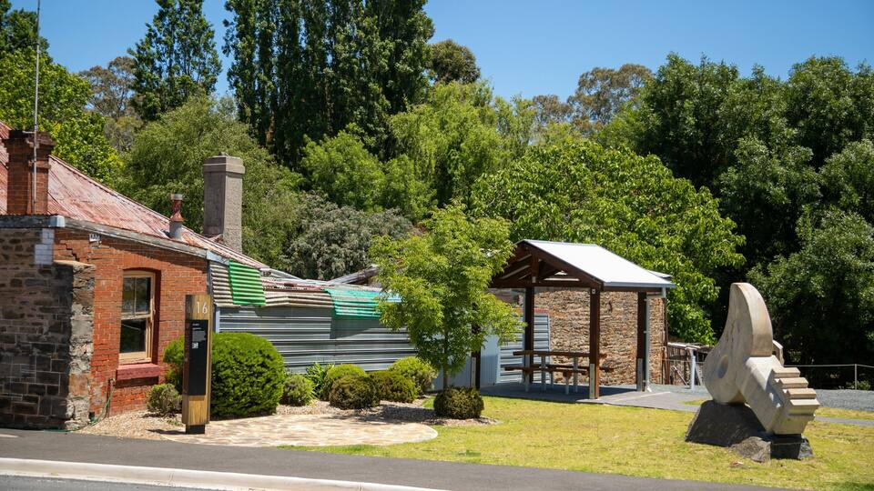 A rustic building with a brick facade, a stone chimney, and a metal roof.
