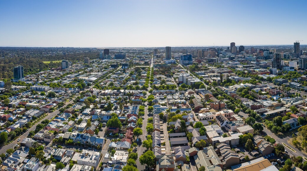 A cityscape with dense residential areas, a mix of modern and older buildings, and a large green park area.