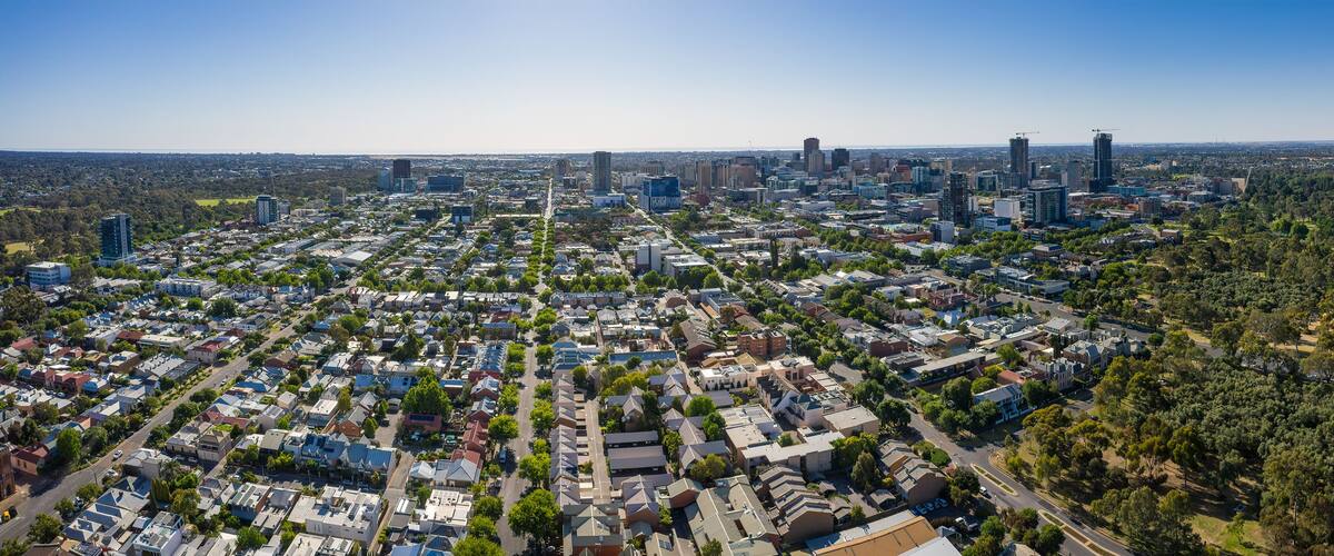 A cityscape with dense residential areas, a mix of modern and older buildings, and a large green park area.