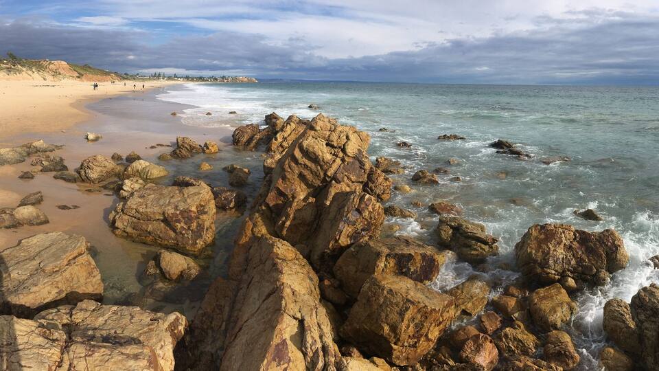 A rocky shoreline with waves crashing onto the beach.