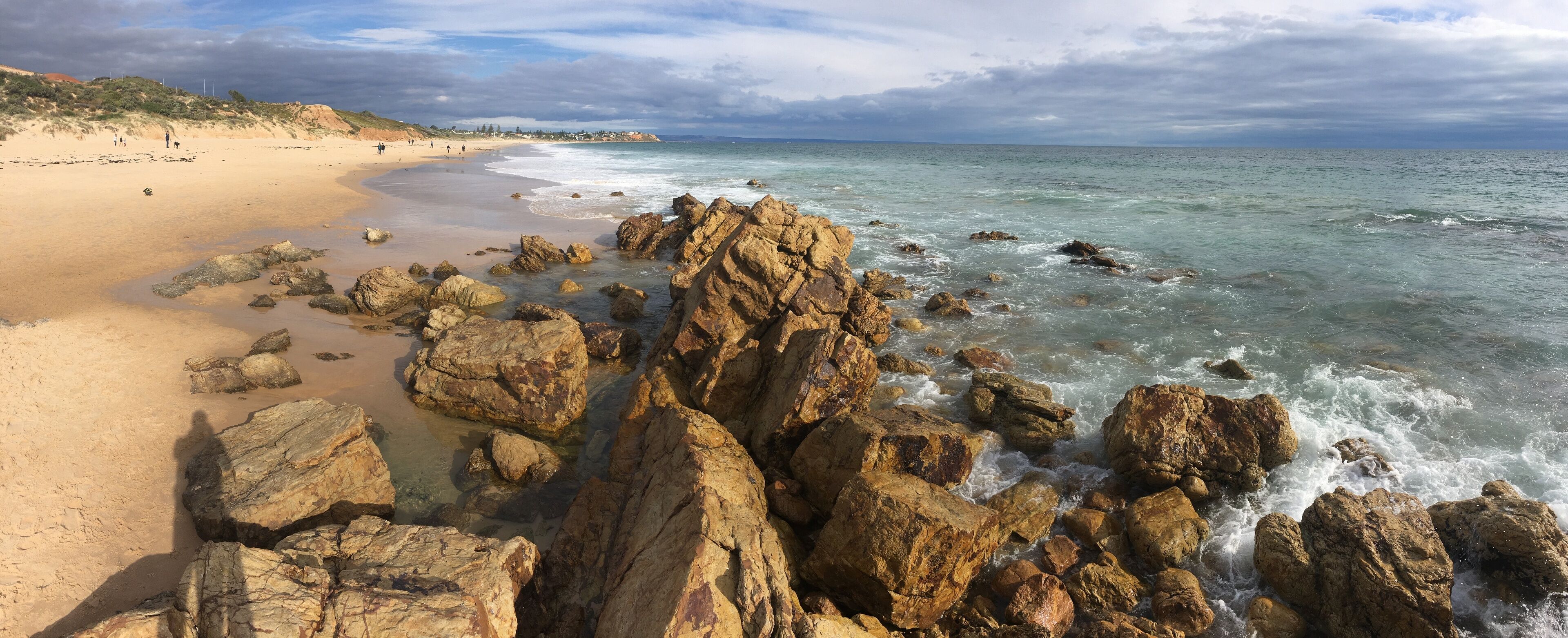 A rocky shoreline with waves crashing onto the beach.