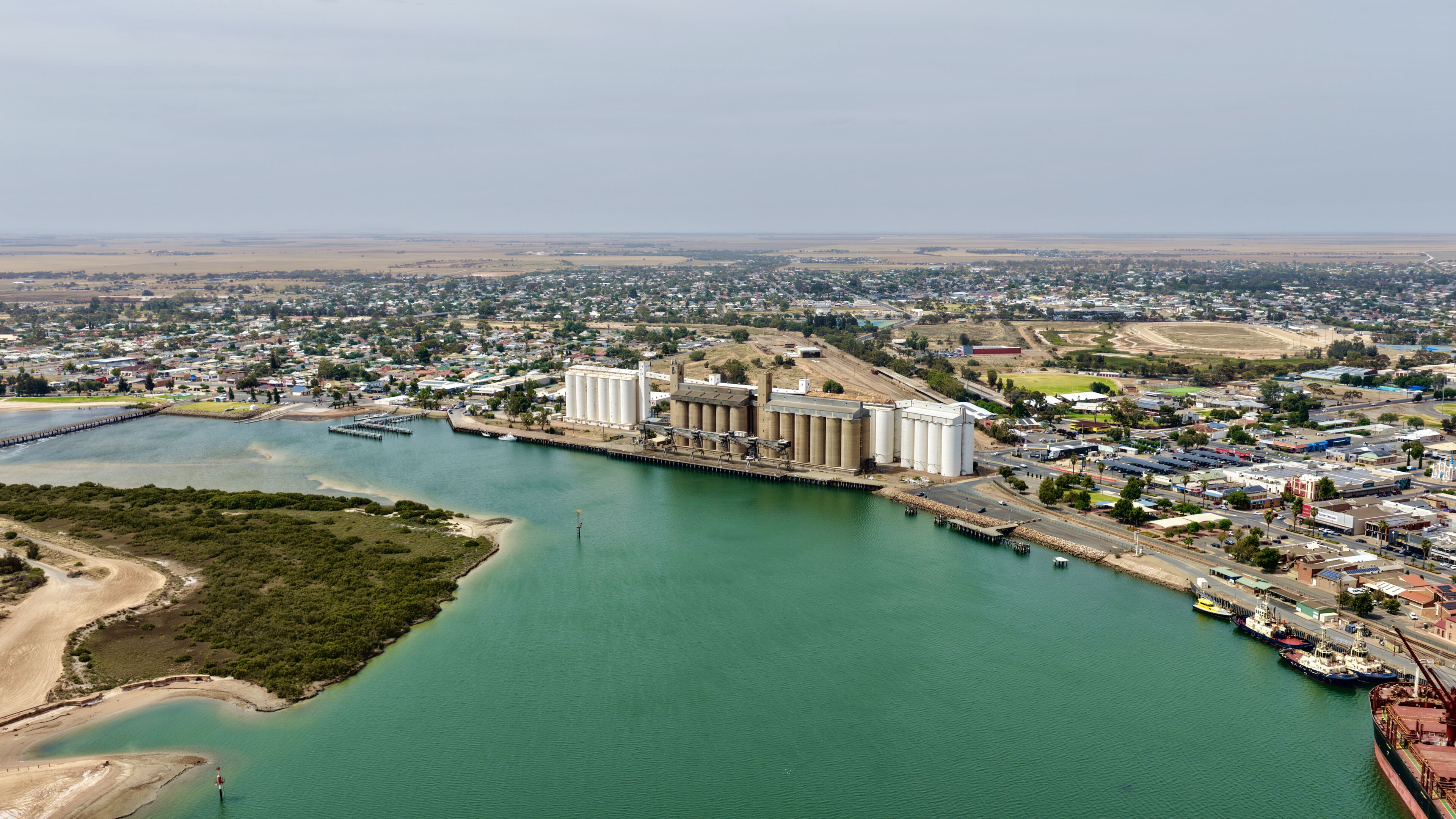 Port Pirie, South Australia: aerial drone view of coastal city, jetty, harbour, industrial port, suburban houses, residential estates, mangrove and Spencer Gulf shoreline