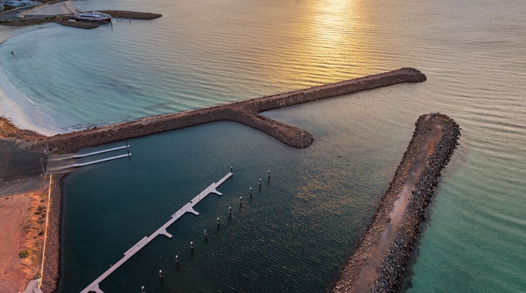 Sunset over rock breakwaters in a blue sea at dusk